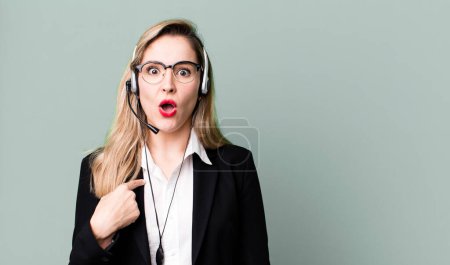 Photo for Looking shocked and surprised with mouth wide open, pointing to self. telemarketer concept - Royalty Free Image