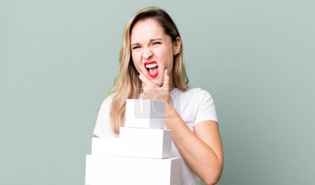 Photo for With mouth and eyes wide open and hand on chin. white boxes concept - Royalty Free Image