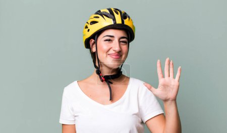 Photo for Smiling and looking friendly, showing number five. bike helmet concept - Royalty Free Image