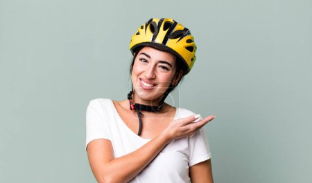 Téléchargez les photos : Smiling cheerfully, feeling happy and showing a concept. bike helmet concept - en image libre de droit