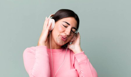Photo for Pretty hismanic woman listening music and dancing - Royalty Free Image
