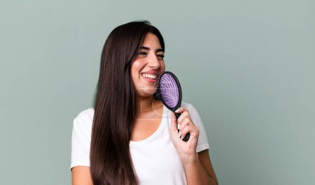 Foto de Pretty hispanic woman using a hair comb - Imagen libre de derechos