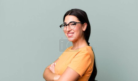 Foto de Sonriendo a la cámara con los brazos cruzados y una expresión feliz, segura, satisfecha, vista lateral - Imagen libre de derechos