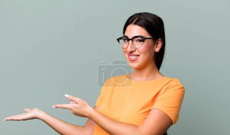 Photo for Smiling, feeling happy, carefree and satisfied, pointing to concept or idea on copy space on the side - Royalty Free Image