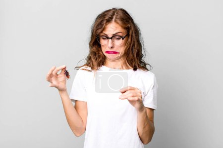 Photo for Hispanic pretty young woman holding a cockroach. disease concept - Royalty Free Image