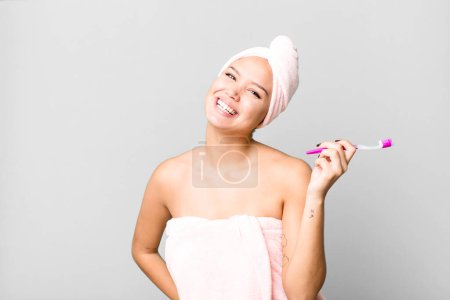 Téléchargez les photos : Hispanic pretty young woman wearing bathrobe ang a teeth brush - en image libre de droit