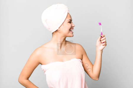 Téléchargez les photos : Hispanic pretty young woman wearing bathrobe ang a teeth brush - en image libre de droit