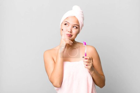Photo for Hispanic pretty young woman wearing bathrobe ang a teeth brush - Royalty Free Image