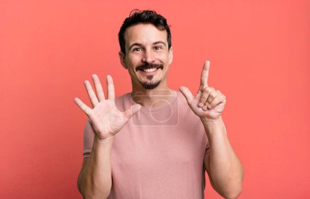Photo for Smiling and looking friendly, showing number seven or seventh with hand forward, counting down - Royalty Free Image