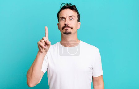 Photo for Feeling like a genius holding finger proudly up in the air after realizing a great idea, saying eureka - Royalty Free Image