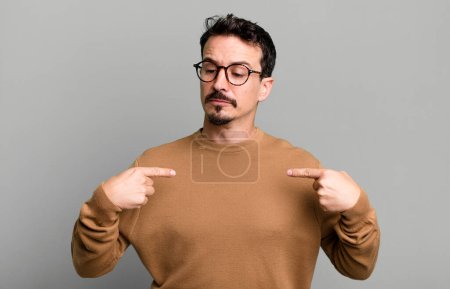 Photo for Looking proud, positive and casual pointing to chest with both hands - Royalty Free Image