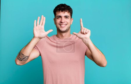 Foto de Hombre sonriendo y mirando amigable, mostrando el número siete o séptimo con la mano hacia adelante, cuenta atrás - Imagen libre de derechos