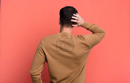 Photo for Man thinking or doubting, scratching head, feeling puzzled and confused, back or rear view - Royalty Free Image