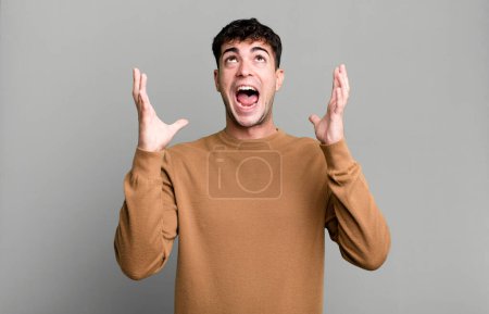 Téléchargez les photos : Homme se sentant heureux, étonné, chanceux et surpris, célébrant la victoire avec les deux mains en l'air - en image libre de droit