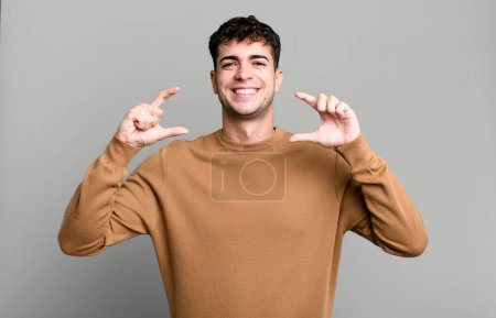 Foto de Man framing or outlining own smile with both hands, looking positive and happy, wellness concept - Imagen libre de derechos