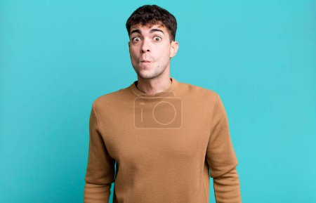 Photo for Man with a goofy, crazy, surprised expression, puffing cheeks, feeling stuffed, fat and full of food - Royalty Free Image