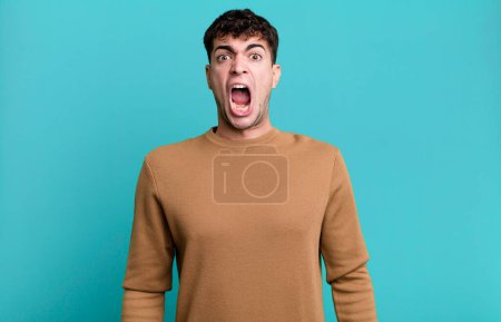 Téléchargez les photos : Homme se sentant terrifié et choqué, la bouche grande ouverte dans la surprise - en image libre de droit