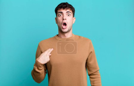 Téléchargez les photos : Homme regardant choqué et surpris avec la bouche grande ouverte, pointant vers soi-même - en image libre de droit