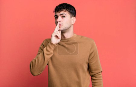 Photo for Man asking for silence and quiet, gesturing with finger in front of mouth, saying shh or keeping a secret - Royalty Free Image