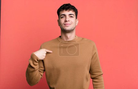 Téléchargez les photos : Homme à l'air fier, confiant et heureux, souriant et pointant vers soi ou faisant signe numéro un - en image libre de droit