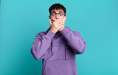 Photo for Man covering mouth with hands with a shocked, surprised expression, keeping a secret or saying oops - Royalty Free Image