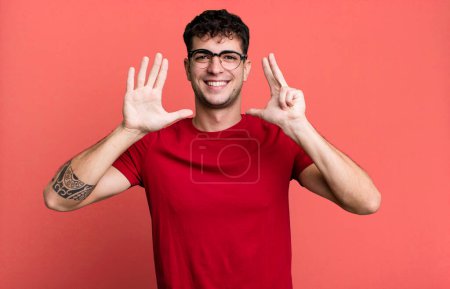 Foto de Sonriendo y mirando amigable, mostrando el número ocho u octavo con la mano hacia adelante, cuenta atrás - Imagen libre de derechos