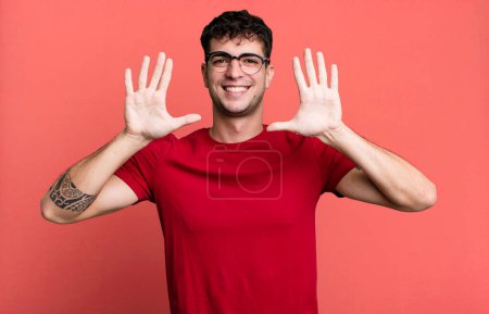 Foto de Sonriendo y mirando amistoso, mostrando el número diez o décimo con la mano hacia adelante, cuenta atrás - Imagen libre de derechos
