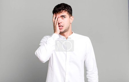 Photo for Man feeling bored, frustrated and sleepy after a tiresome, dull and tedious task, holding face with hand - Royalty Free Image