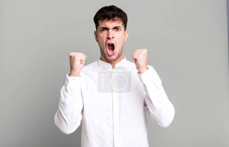 Téléchargez les photos : Homme criant agressivement avec une expression en colère ou avec les poings serrés célébrant le succès - en image libre de droit