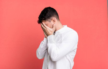 Photo for Man covering eyes with hands with a sad, frustrated look of despair, crying, side view - Royalty Free Image