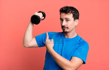 Téléchargez les photos : Adult man training and lifting a dumbbell - en image libre de droit