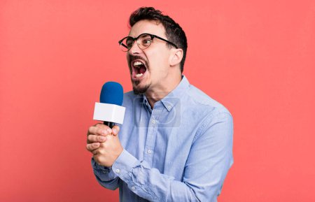 Téléchargez les photos : Adult man journalist or presenter with a microphone - en image libre de droit