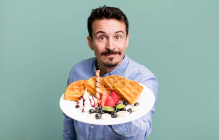 Téléchargez les photos : Adult man having waffles for breakfast - en image libre de droit
