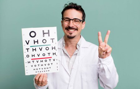 Photo for Adult man smiling and looking happy, gesturing victory or peace. optical vision test concept - Royalty Free Image
