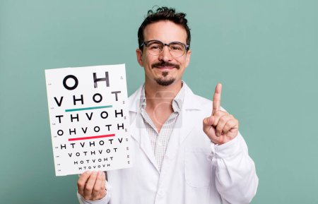 Foto de Adult man smiling and looking friendly, showing number one. optical vision test concept - Imagen libre de derechos