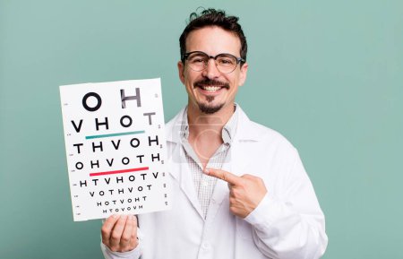 Photo for Adult man smiling cheerfully, feeling happy and pointing to the side. optical vision test concept - Royalty Free Image