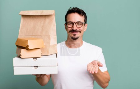 Foto de Adult man smiling happily with friendly and  offering and showing a concept. fast food delivery and take away concept - Imagen libre de derechos