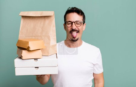 Photo for Adult man with cheerful and rebellious attitude, joking and sticking tongue out. fast food delivery and take away concept - Royalty Free Image