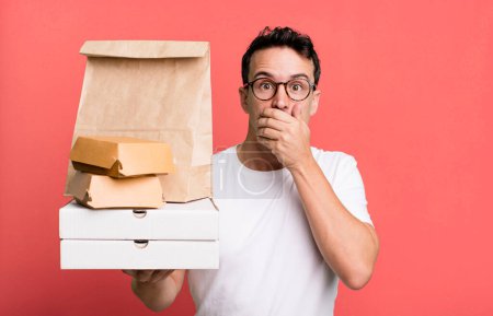 Téléchargez les photos : Adult man covering mouth with hands with a shocked. fast food delivery and take away concept - en image libre de droit