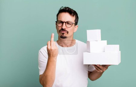 Foto de Adult man feeling angry, annoyed, rebellious and aggressive. blank boxes packaging concept - Imagen libre de derechos