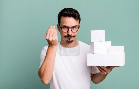 Photo for Adult man making capice or money gesture, telling you to pay. blank boxes packaging concept - Royalty Free Image