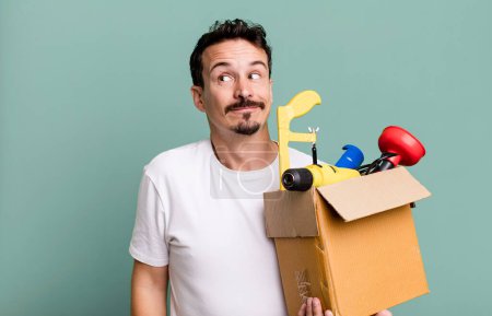 Photo for Adult man shrugging, feeling confused and uncertain. with a toolbox. handyman concept - Royalty Free Image