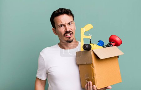 Téléchargez les photos : Adult man feeling puzzled and confused. with a toolbox. handyman concept - en image libre de droit