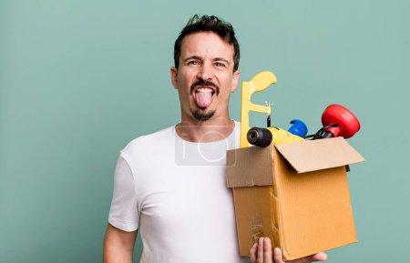 Foto de Adult man feeling disgusted and irritated and tongue out. with a toolbox. handyman concept - Imagen libre de derechos