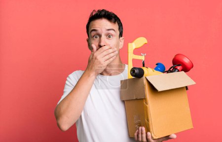 Photo for Adult man covering mouth with hands with a shocked. with a toolbox. handyman concept - Royalty Free Image