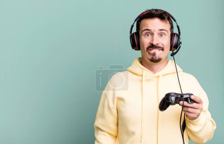 Téléchargez les photos : Adult man looking puzzled and confused with headset and a control. gamer concept - en image libre de droit