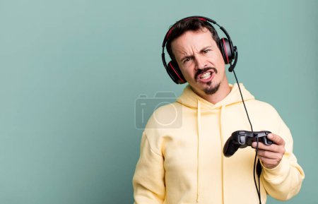Téléchargez les photos : Adult man feeling puzzled and confused with headset and a control. gamer concept - en image libre de droit