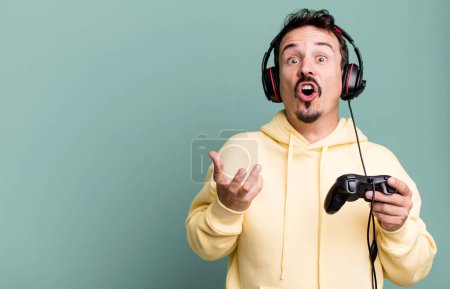 Photo for Adult man feeling extremely shocked and surprised with headset and a control. gamer concept - Royalty Free Image