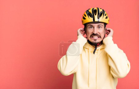 Photo for Adult man feeling stressed, anxious or scared, with hands on head. bike helmet and bicycle concept - Royalty Free Image
