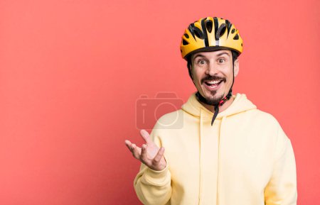 Téléchargez les photos : Adult man feeling happy, surprised realizing a solution or idea. bike helmet and bicycle concept - en image libre de droit